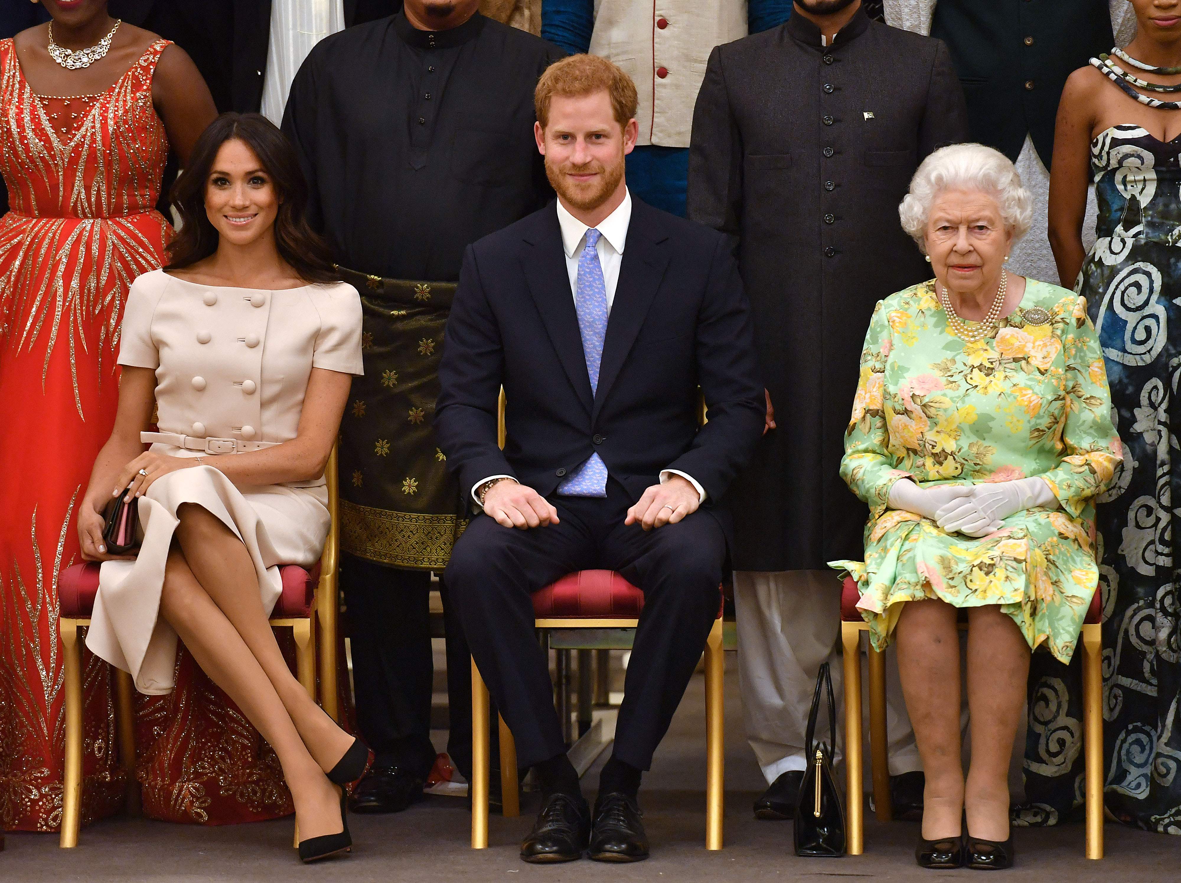 Сассекские с королевой Елизаветой II на церемонии вручения награды Queen's Young Leaders Awards 26 июня 2018 года в Букингемском дворце в Лондоне.